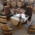 Recycling van oude wijnvaten tot meubilair, stoelen en een tafel met glasplaat.