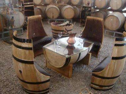 Recycling van oude wijnvaten tot meubilair, stoelen en een tafel met glasplaat.